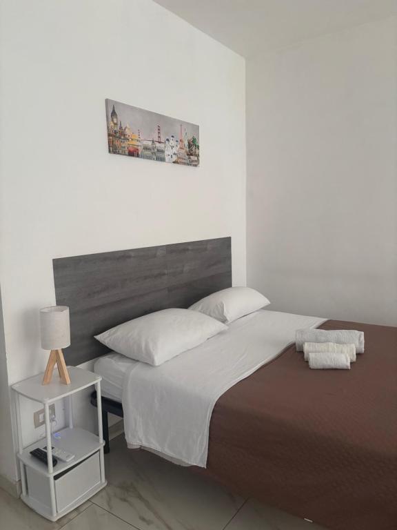 a bedroom with a large bed and a night stand at Sol Casa in Cosenza