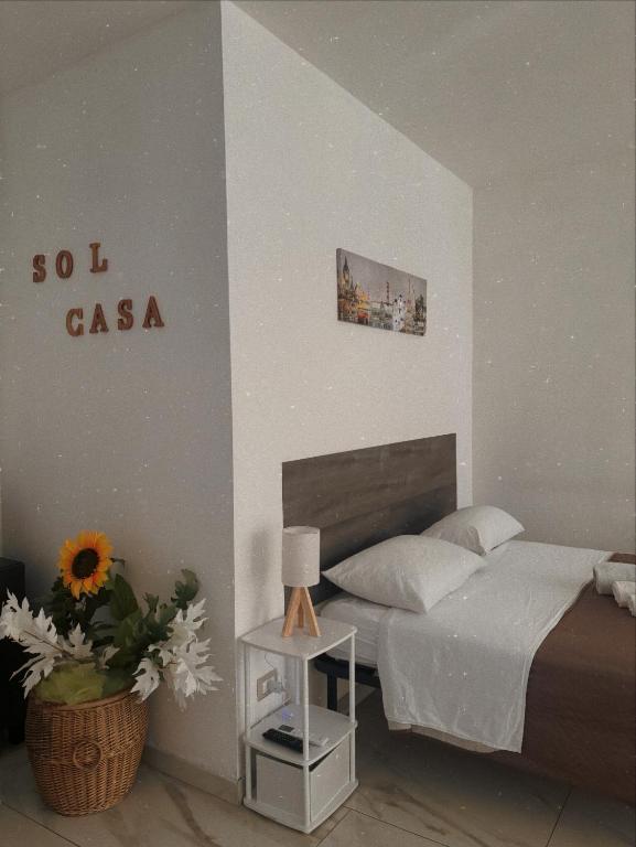 a bedroom with a bed and a table with flowers at Sol Casa in Cosenza
