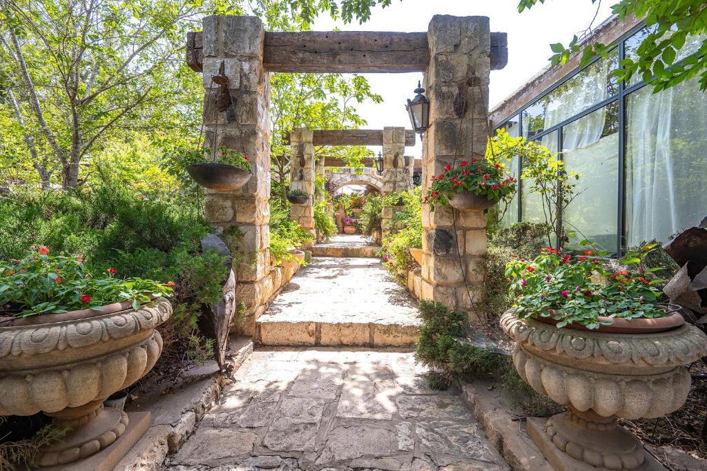 a stone pathway in a garden with potted plants at אחוזת בר in Sha'al