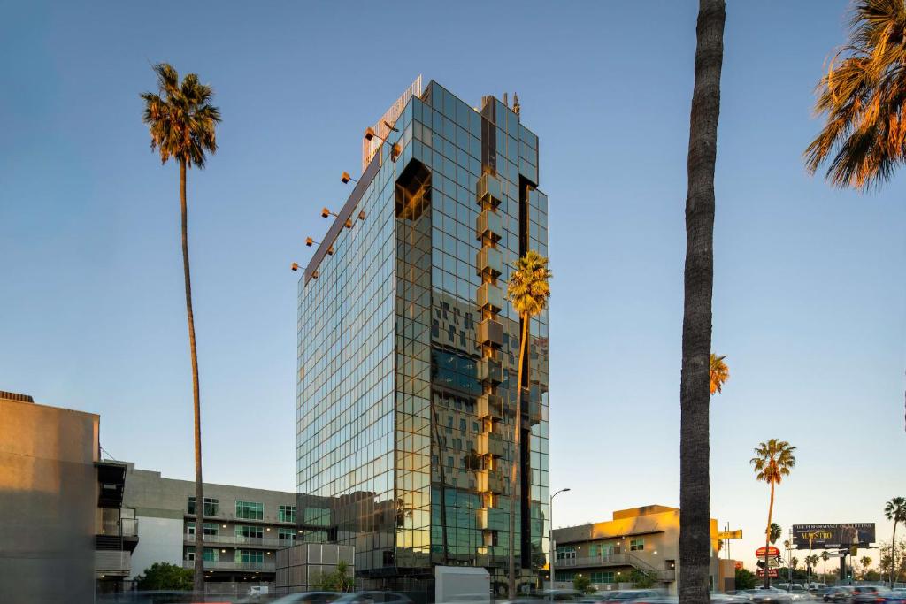 un edificio de cristal alto con palmeras delante en Kasa Sunset Los Angeles, en Los Ángeles