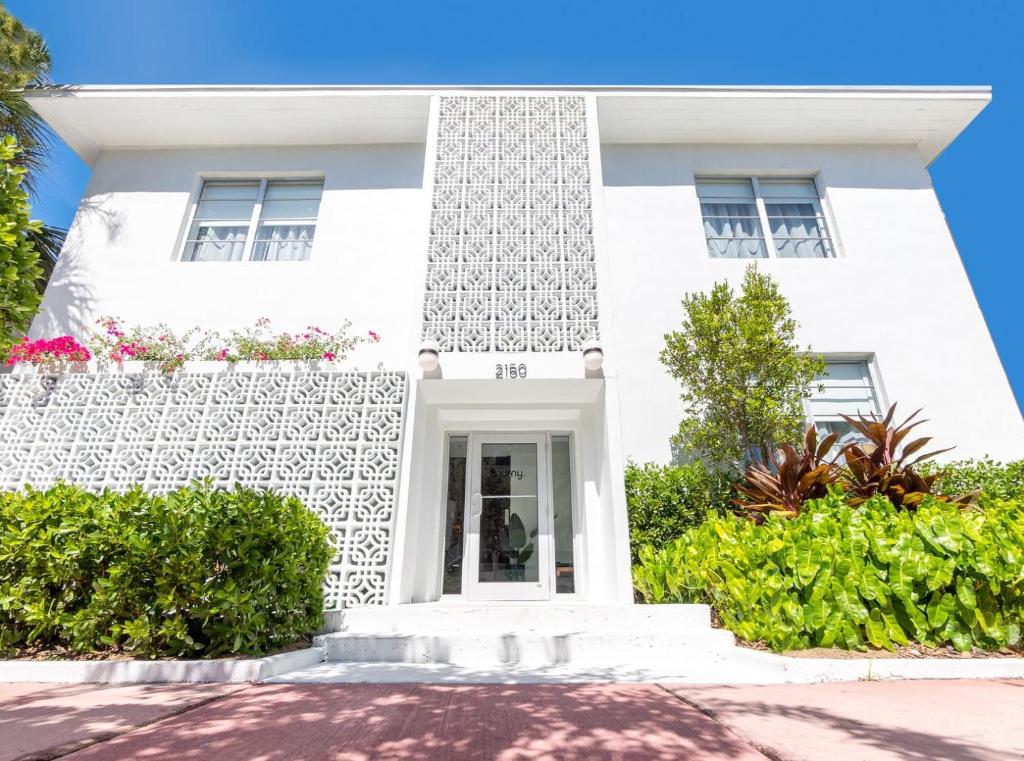 een wit huis met struiken ervoor bij Kasa Collins Park Miami Beach Convention Center in Miami Beach