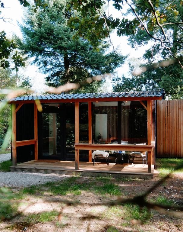 a pavilion with a picnic table and a bench at Forest Cabin in the woods in Holten