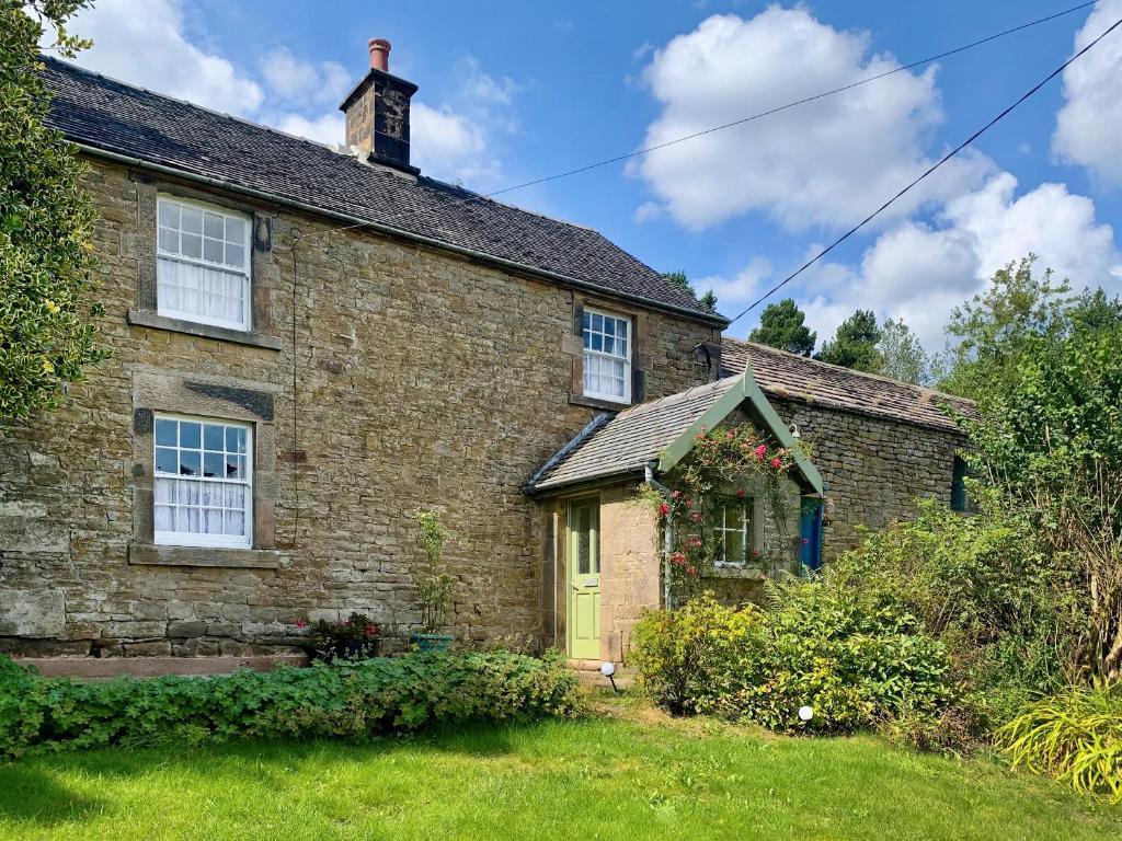 an old brick house with a yellow door at The Homestead in Leek