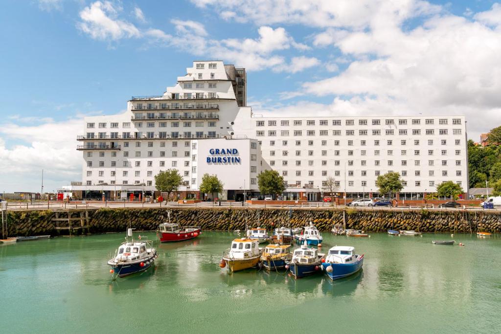 a group of boats in the water in front of a building at The Grand Burstin Hotel in Folkestone
