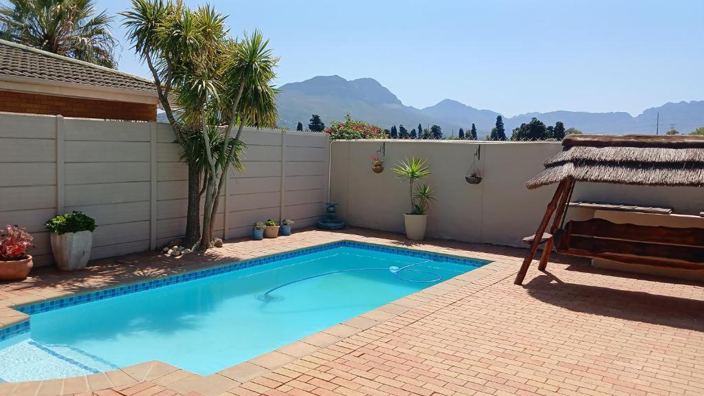 a small blue swimming pool in a backyard at A new apartment with a view at Goedehoop, Strand, Western Cape in Strand