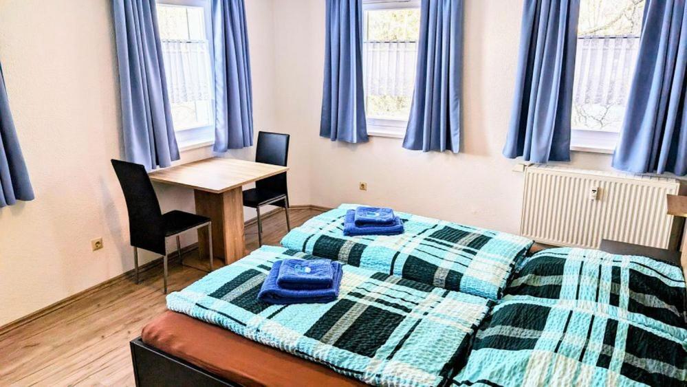 a bedroom with a bed and a desk and windows at Waldhorn Dobel in Dobel