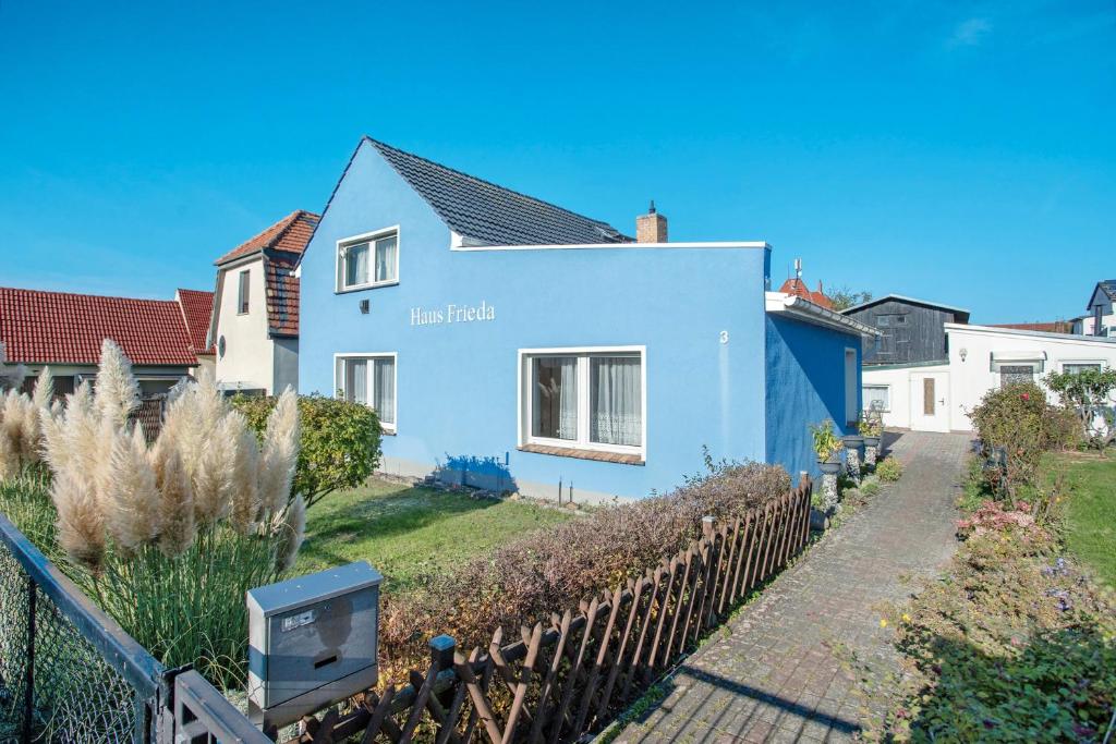 a blue house with a fence in front of it at Haus Frieda in Ostseebad Koserow