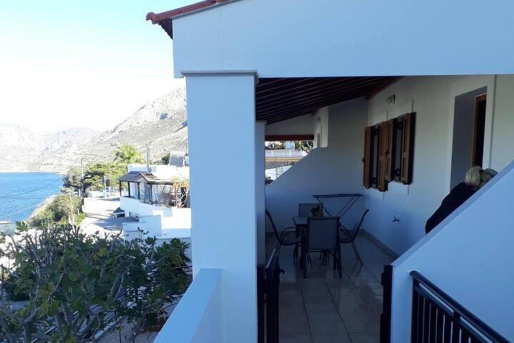a balcony of a house with a view of the ocean at Apartment - Sleeps 5 - Parking - Private Terrace in Masouri