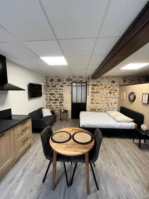 a bedroom with a bed and a table in a room at Les Pichies, Studio Dadoum, Centre ville in Digoin