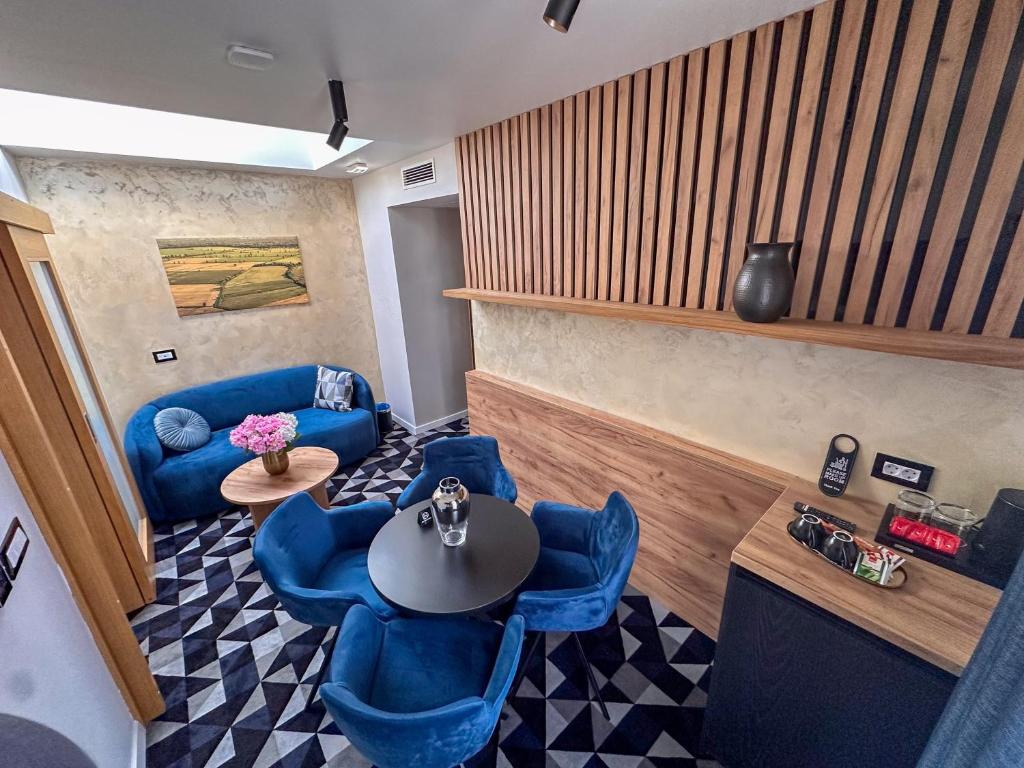 a living room with blue chairs and a table at Hotel Modriča in Modriča