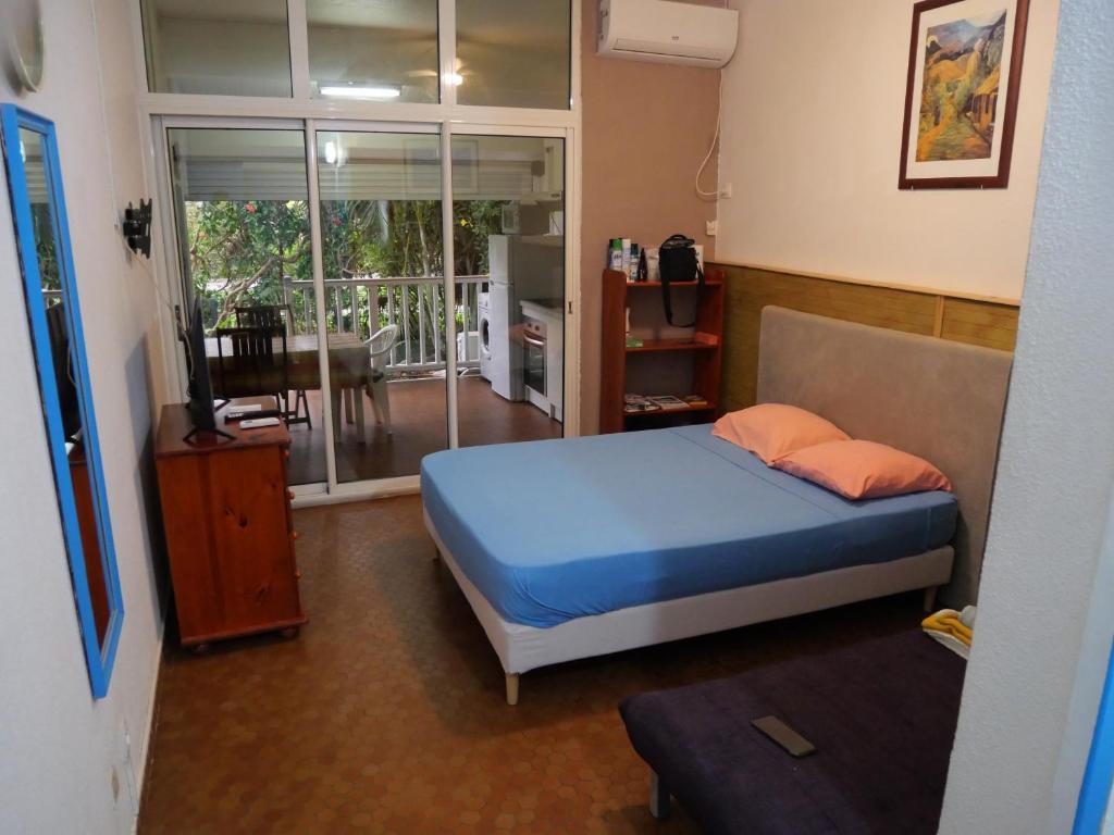 Un dormitorio con una cama azul y un balcón. en STUDIO FACE MARINA, en Saint-François