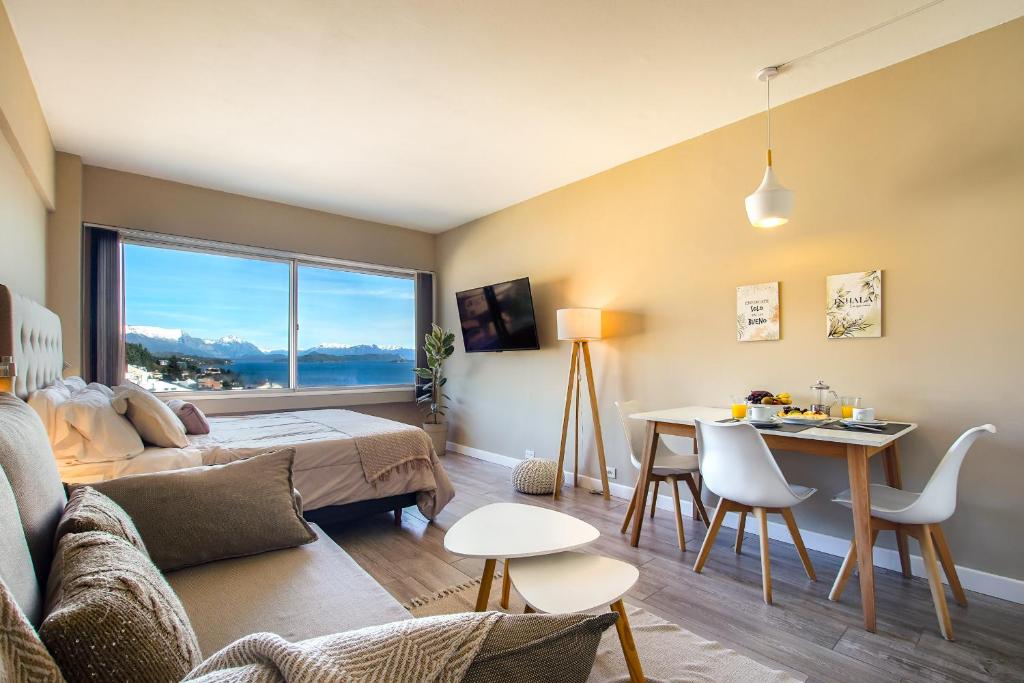 una sala de estar con una cama y una mesa en Postal del Nahuel, en San Carlos de Bariloche