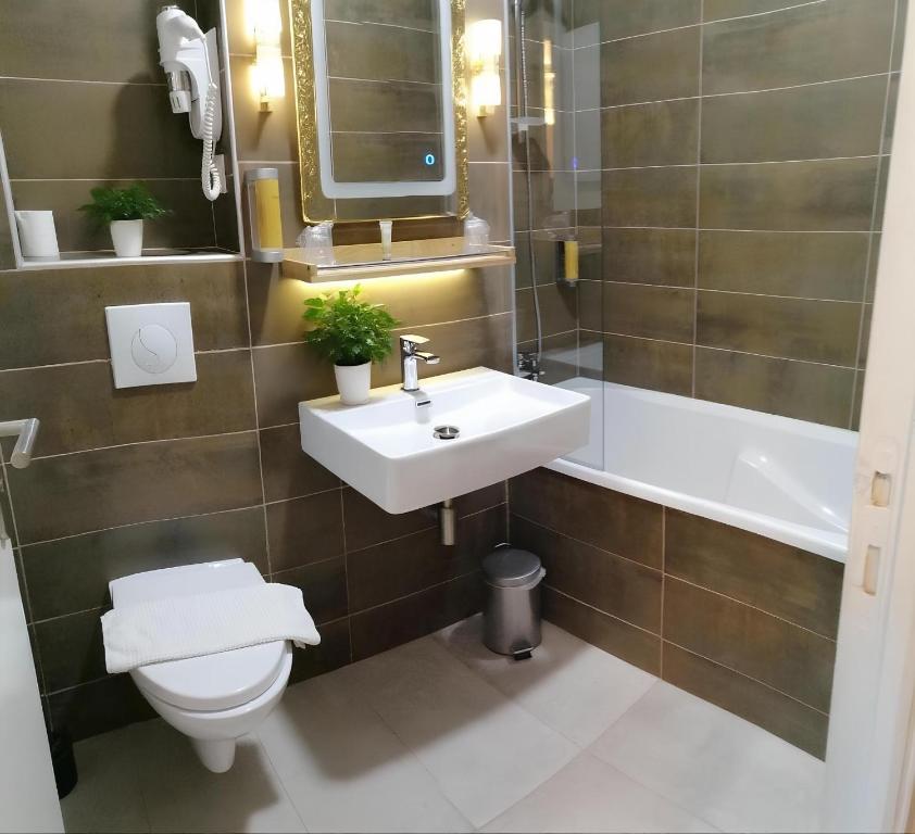 a bathroom with a sink and a toilet and a tub at La Buissonnière in Corbigny