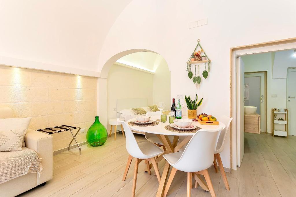 a white dining room with a table and chairs at La Casa di Ninetta - Boutique Stay in Monopoli