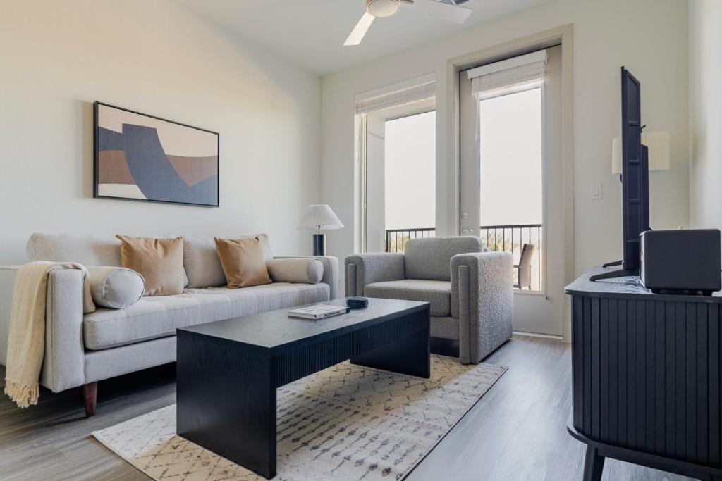 uma sala de estar com um sofá e uma mesa em Blueground Del Valle pool nr McKinney Falls ATX-355 em Austin