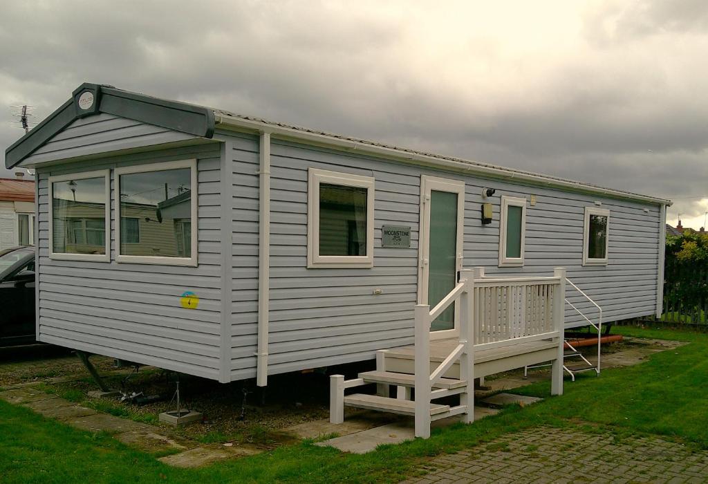 a tiny house with a porch and a staircase at Seaview Moonstone Deluxe 6 Berth central heated FREE WIFI in Ingoldmells