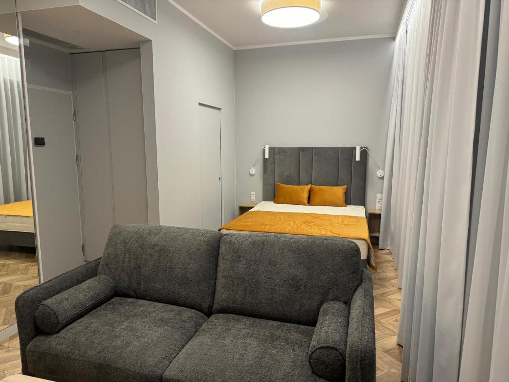 a bedroom with a couch and a bed at Apartament Krab AKTENA Shellter Rogowo in Rogowo