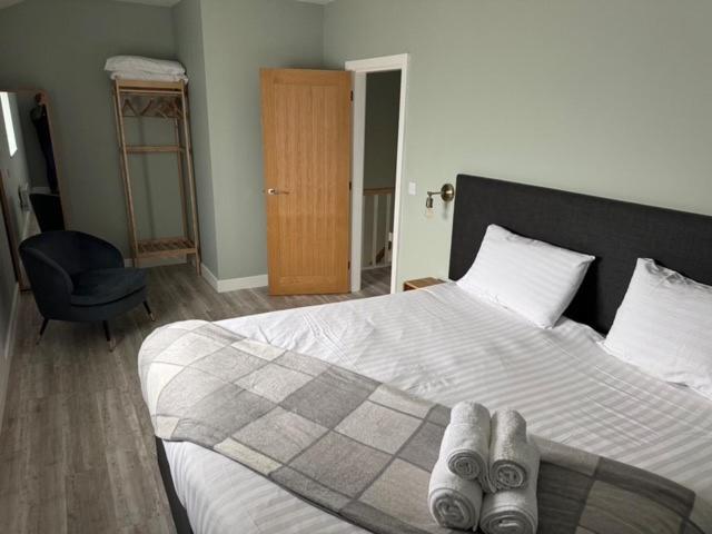 a bedroom with a bed with two pairs of shoes on it at Oakwood Farm Barns in Chester