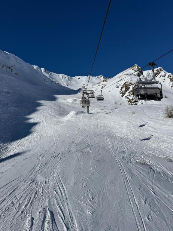a snow covered ski slope with a ski lift at Lo Chalet delle Marmotte in Passo del Tonale