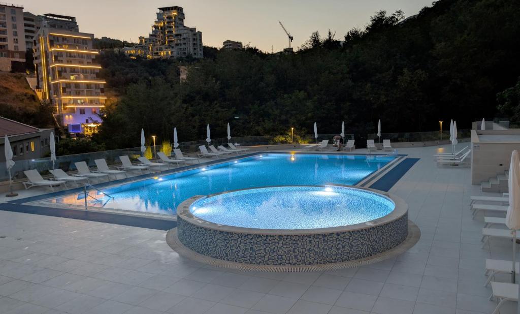 a large swimming pool with chairs and a table at Status-M Apartments 187 in Becici