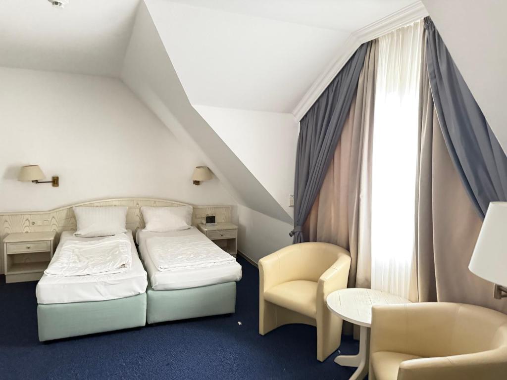 a hotel room with a bed and a desk and chair at HOTEL S Norderstedt in Norderstedt