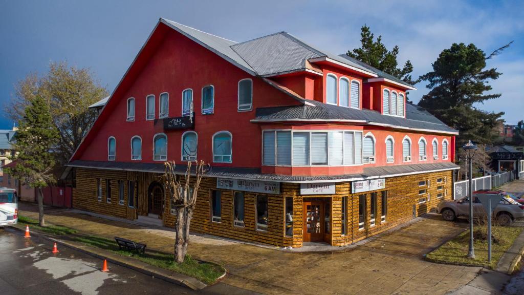ein großes rotes Gebäude mit einem roten in der Unterkunft Darwin Hotel in Puerto Natales