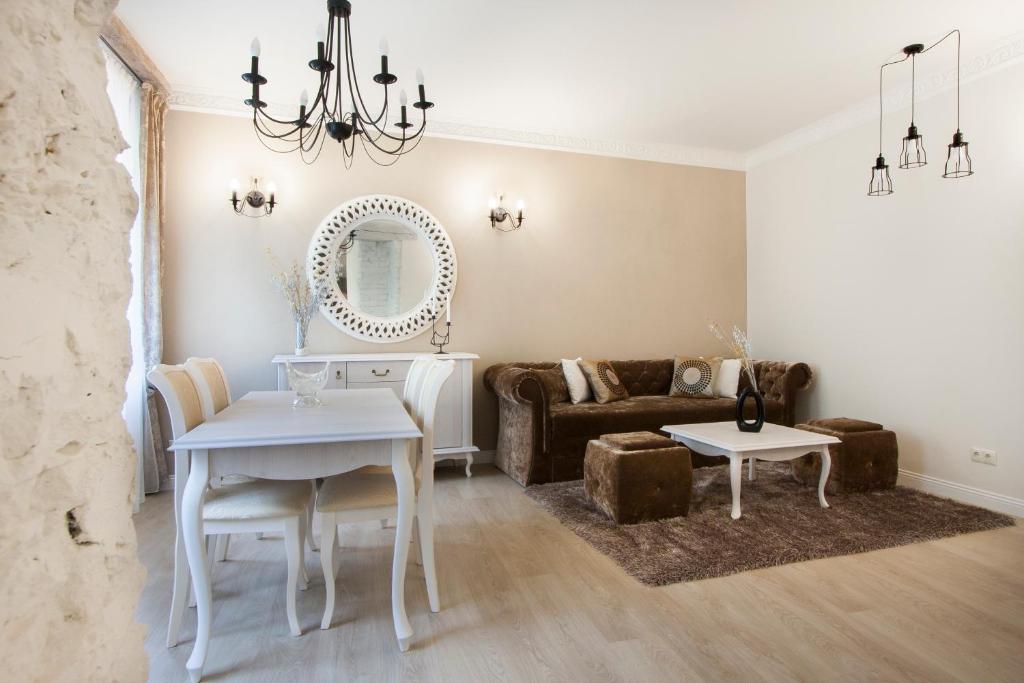 a living room with a white table and a couch at Apartments Satva in Vilnius