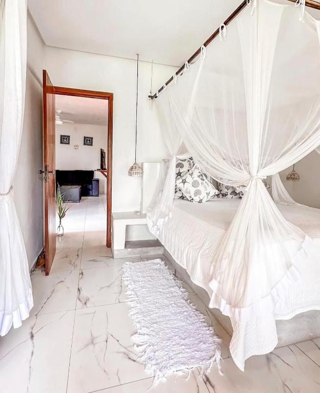 a bedroom with a bed with a mosquito net at Casa Marrocos Arraial d'Ajuda in Arraial d'Ajuda