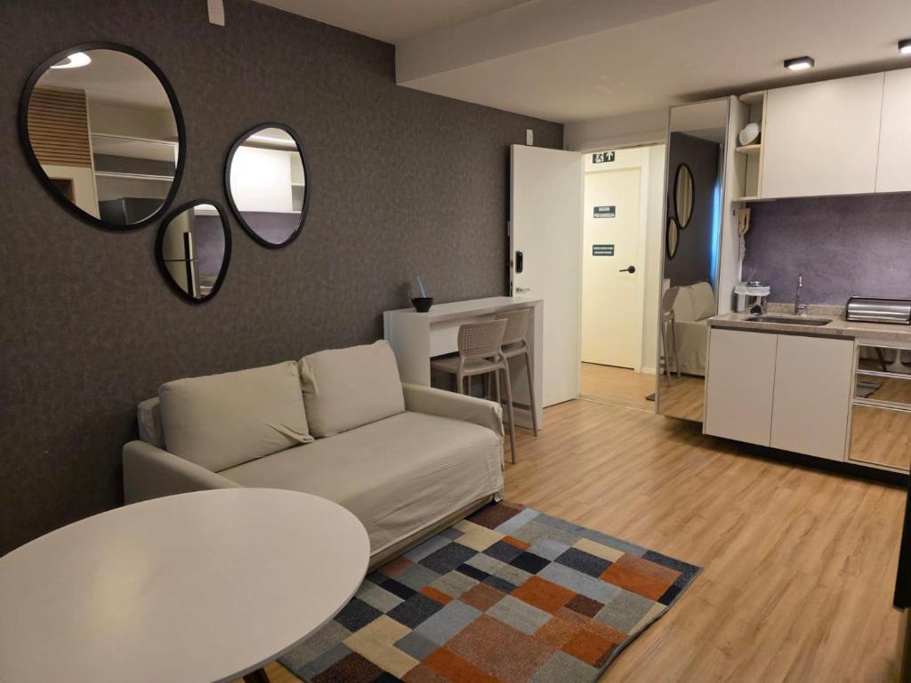 a living room with a couch and a table and a kitchen at FLAT de luxo mobiliado na Savassi in Belo Horizonte