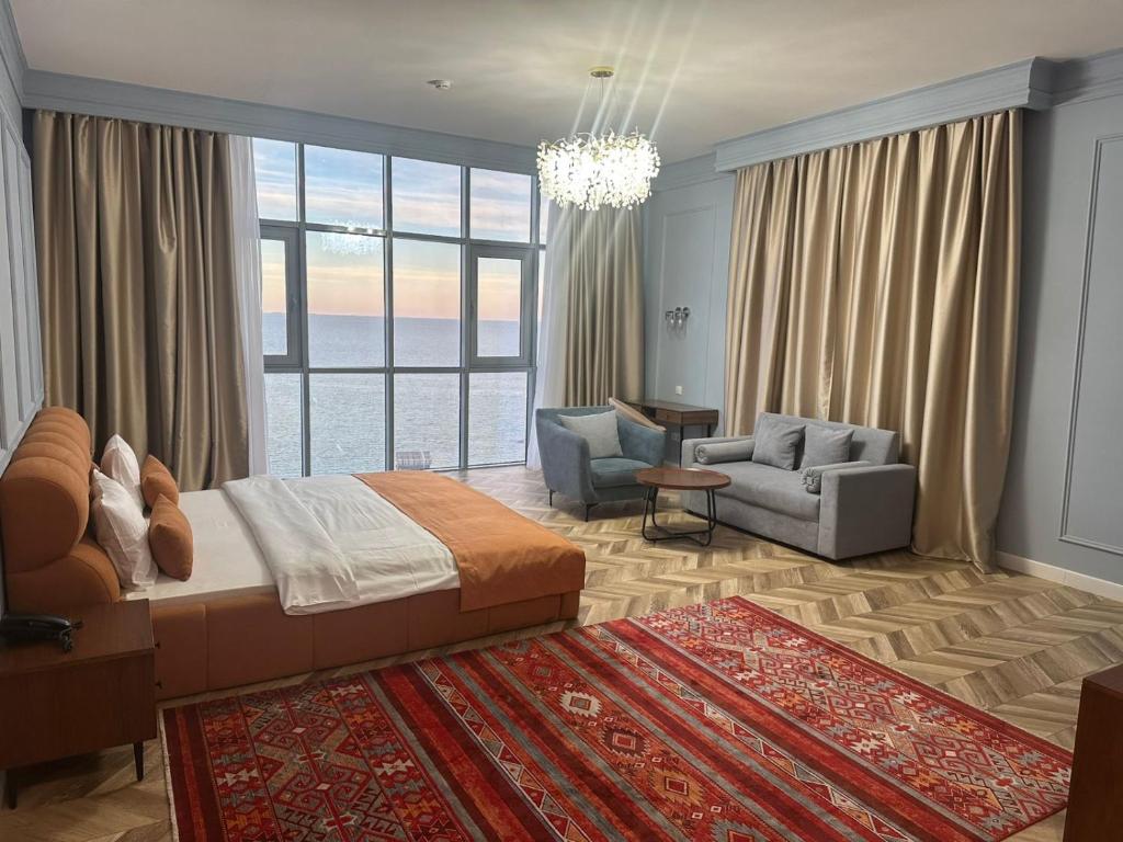 アクタウにあるBoutique Hotel "White HiLL"の大きなベッドとリビングルームのある寝室