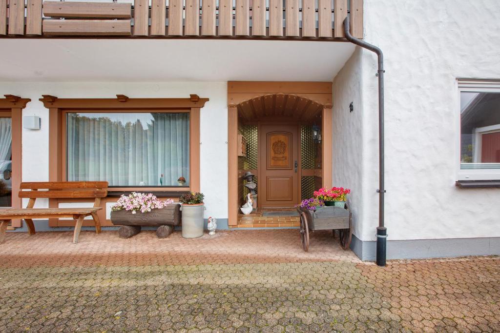 eine Veranda eines Hauses mit einer Bank und Blumen in der Unterkunft Haus Thomann in Höchenschwand