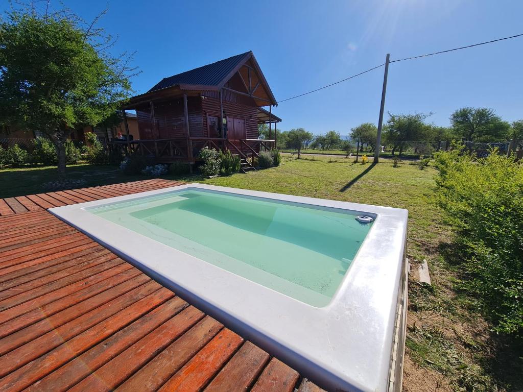 - une piscine sur une terrasse avec une maison dans l'établissement Cabañas en Los Reartes Córdoba, à Villa General Belgrano