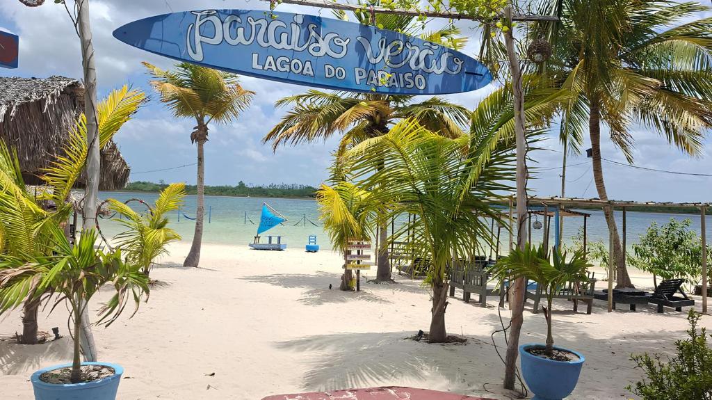 a beach with palm trees and a sign on it at Pousada Paraiso Verão in Jijoca de Jericoacoara