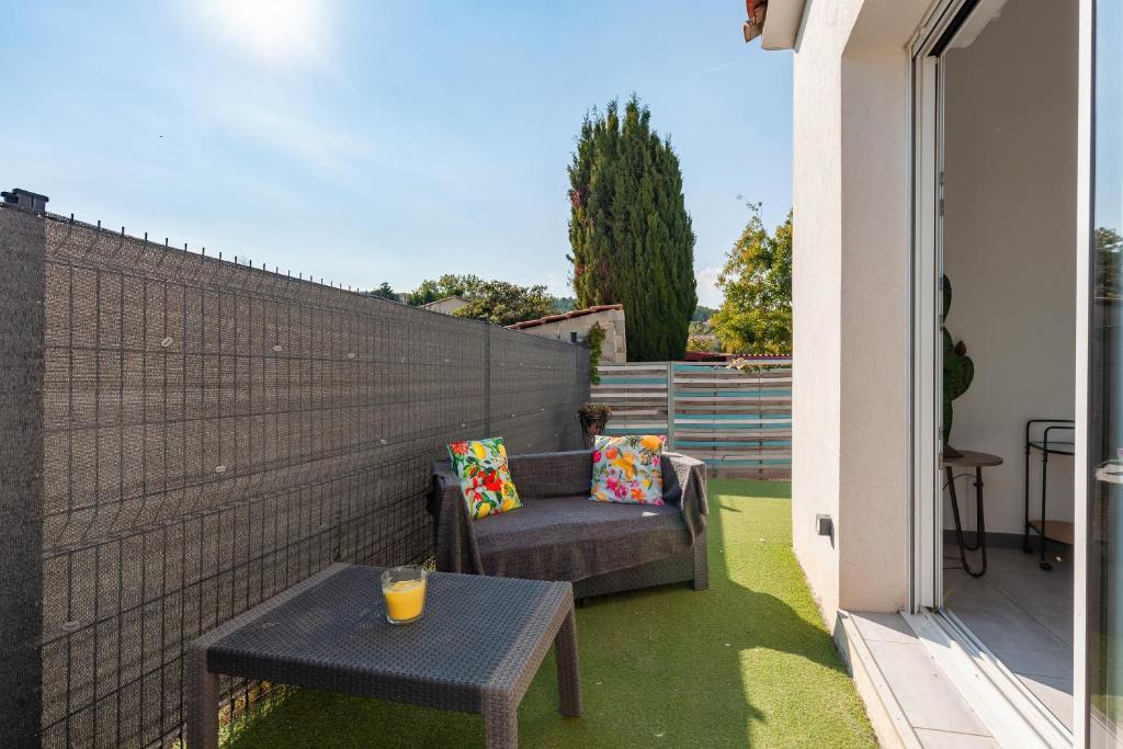 a patio with a chair and a table and a fence at Maison Mexico in Saint-Mitre-les-Remparts