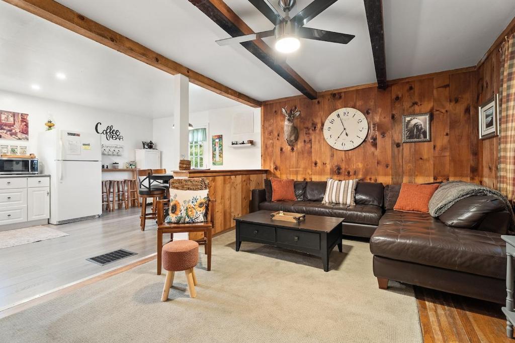 a living room with a couch and a clock on the wall at Rustic Cabin Getaway Close to Everything Fun! in Beaver Dams