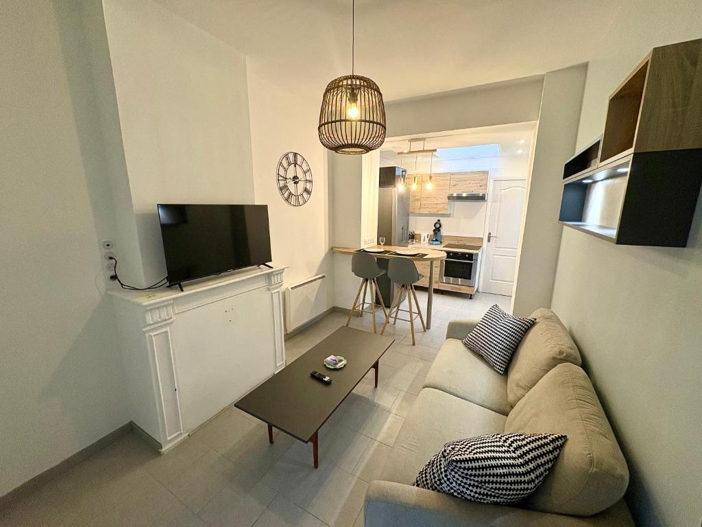 a living room with a couch and a table at Charmant T2 en RDC Centre Douai Netflix in Douai