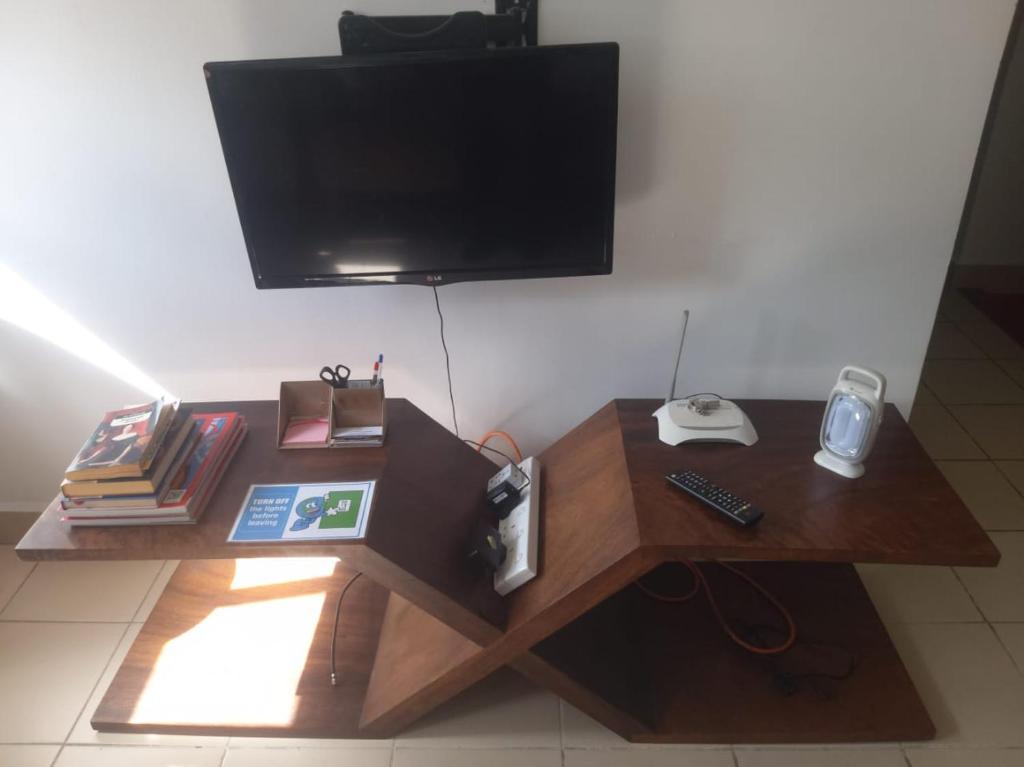 a wooden table with a tv on top of it at SkyLine 19 Apartment in Colombo