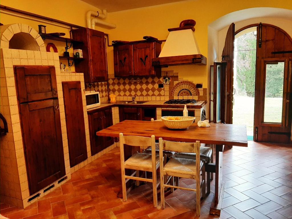 a kitchen with a wooden table and some chairs at Villa Finetti in Gubbio