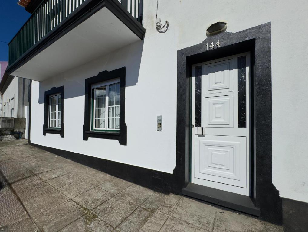 a white door on the side of a building at Biscoitos-Upstudio in Biscoitos