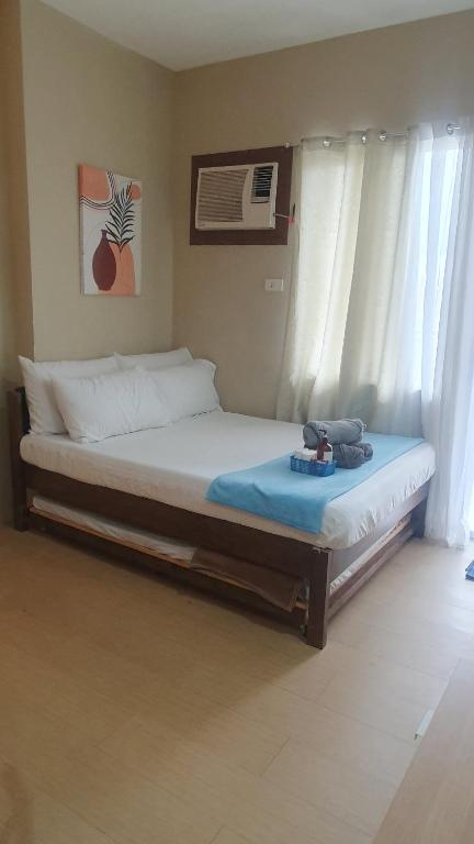 a bed sitting in a room with a window at Studio Condo Unit with Balcony Avida IT Park in Cebu City