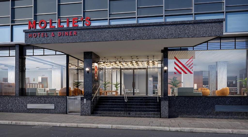 Mollie's Manchester في مانشستر: مبنى فندق وعشاء مع لافتة عليه