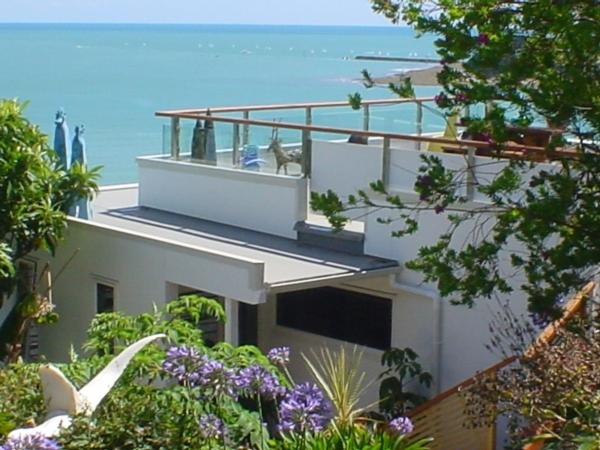 a house with a balcony with the ocean in the background at Beach side Apartment Nelson in Nelson