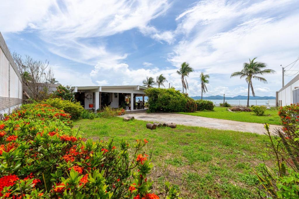 a house with a garden with flowers and palm trees at Casa Punta Chame in Punta Chame