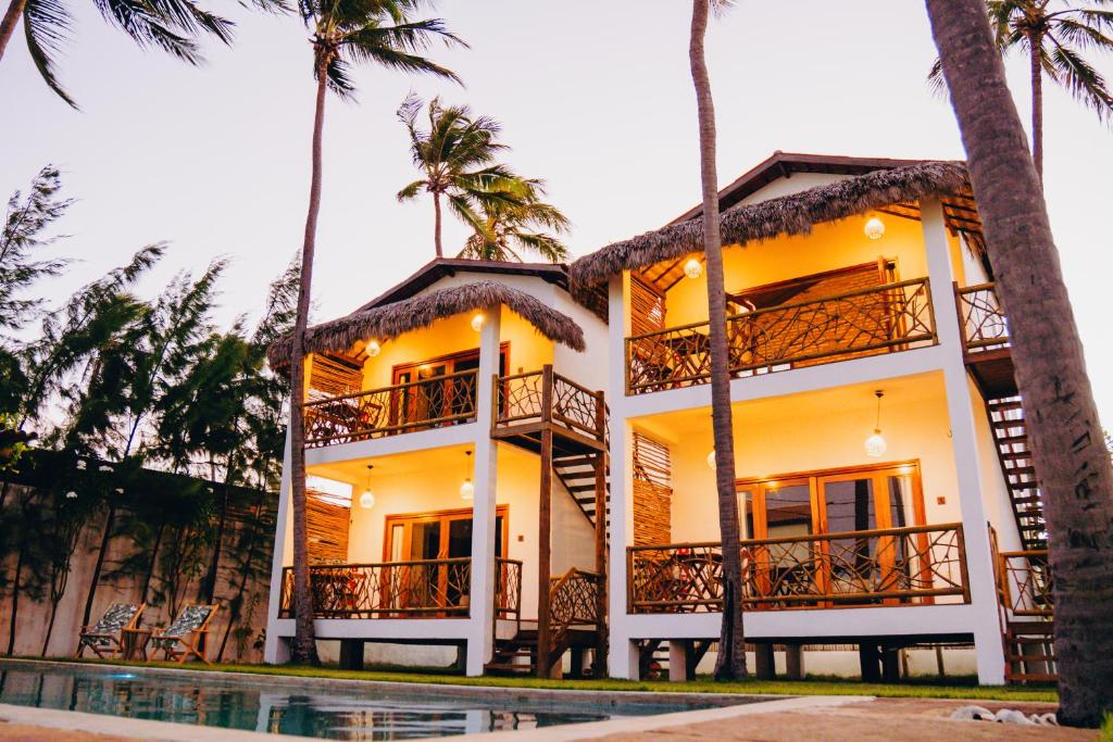 a building with palm trees and a swimming pool at Casa de Coco Icarai in Icaraí