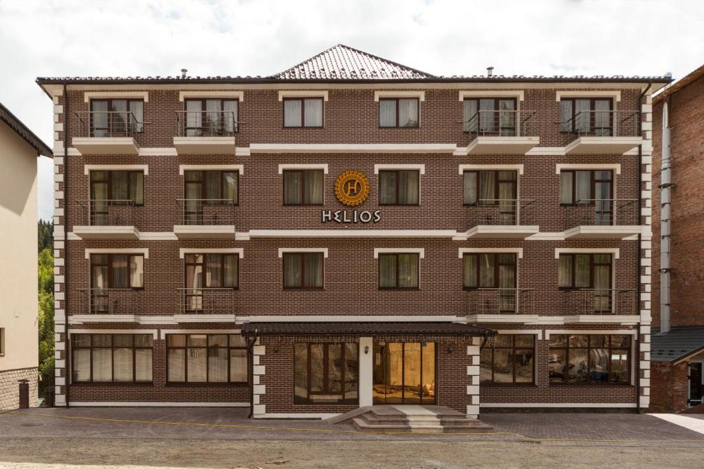 Un gran edificio de ladrillo con un cartel de Hilton. en Helios Hotel & SPA, en Bukovel