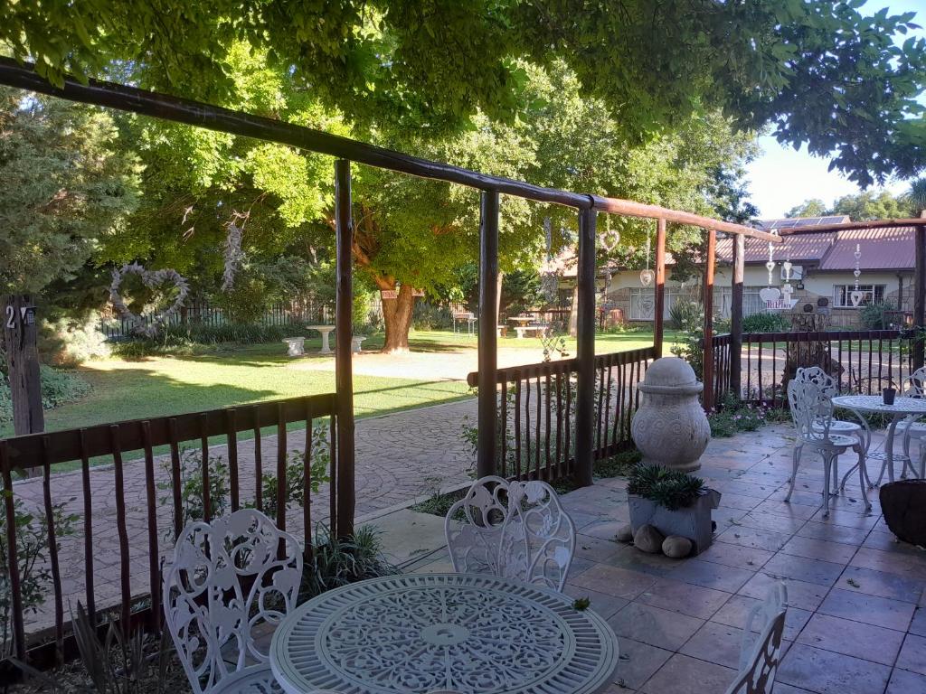 a patio with a table and chairs and a fence at Pumba's B&B in Sannieshof