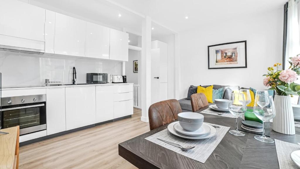 a kitchen and a living room with a table and a kitchen at Stylish 2-Bed flat in E17 in London