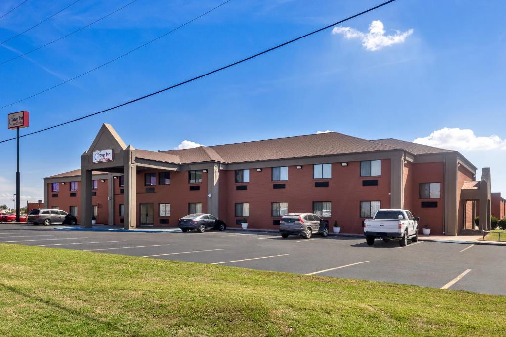 a hotel with cars parked in a parking lot at Travel Inn and Suites- Sikeston Miner I-55 exit-67 in Sikeston