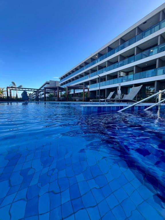 a swimming pool in front of a building at Beach Class Resort - Porto de Galinhas- Praia do Cupe in Porto De Galinhas