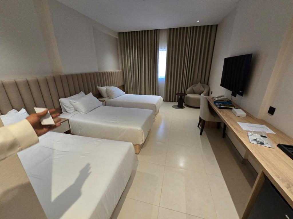 une chambre d'hôtel avec deux lits et une télévision dans l'établissement فندق دفلى اثنان, à La Mecque
